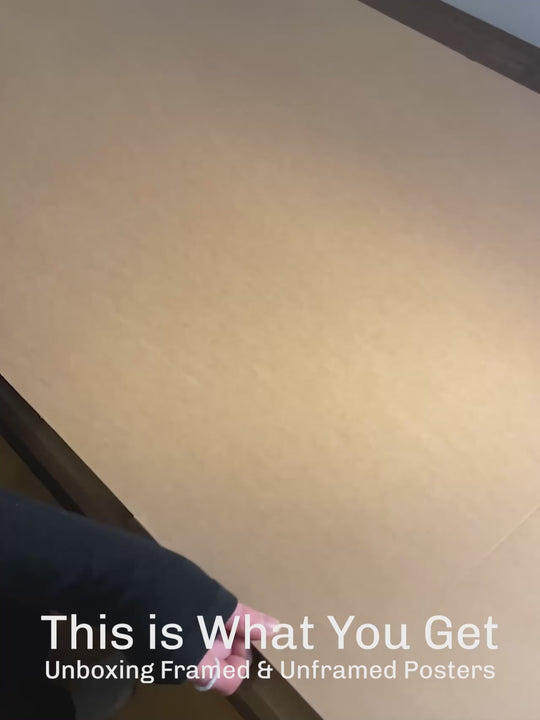 Real-life photo of an unboxing process showing a framed poster inside secure packaging. Includes protective layers and vivid artwork, illustrating what customers receive with their order.