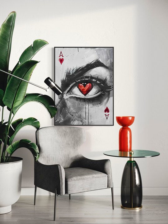 Surreal wall art featuring a close up eye with a red heart pupil inspired by the Ace of Hearts playing card, displayed in a modern minimalist interior with neutral walls, plants, and contemporary furniture.
