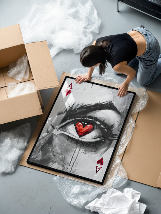 A striking modern wall art print showing a grayscale painted eye with a vivid red heart-shaped pupil, inspired by Ace of Hearts card symbolism. The textured brushstrokes, dripping details, and sharp contrasts create an expressive contemporary focal point. Printed on premium matte museum-grade paper, framed in a sleek black aluminum frame with shatterproof plexiglass for a high-quality, long-lasting finish.