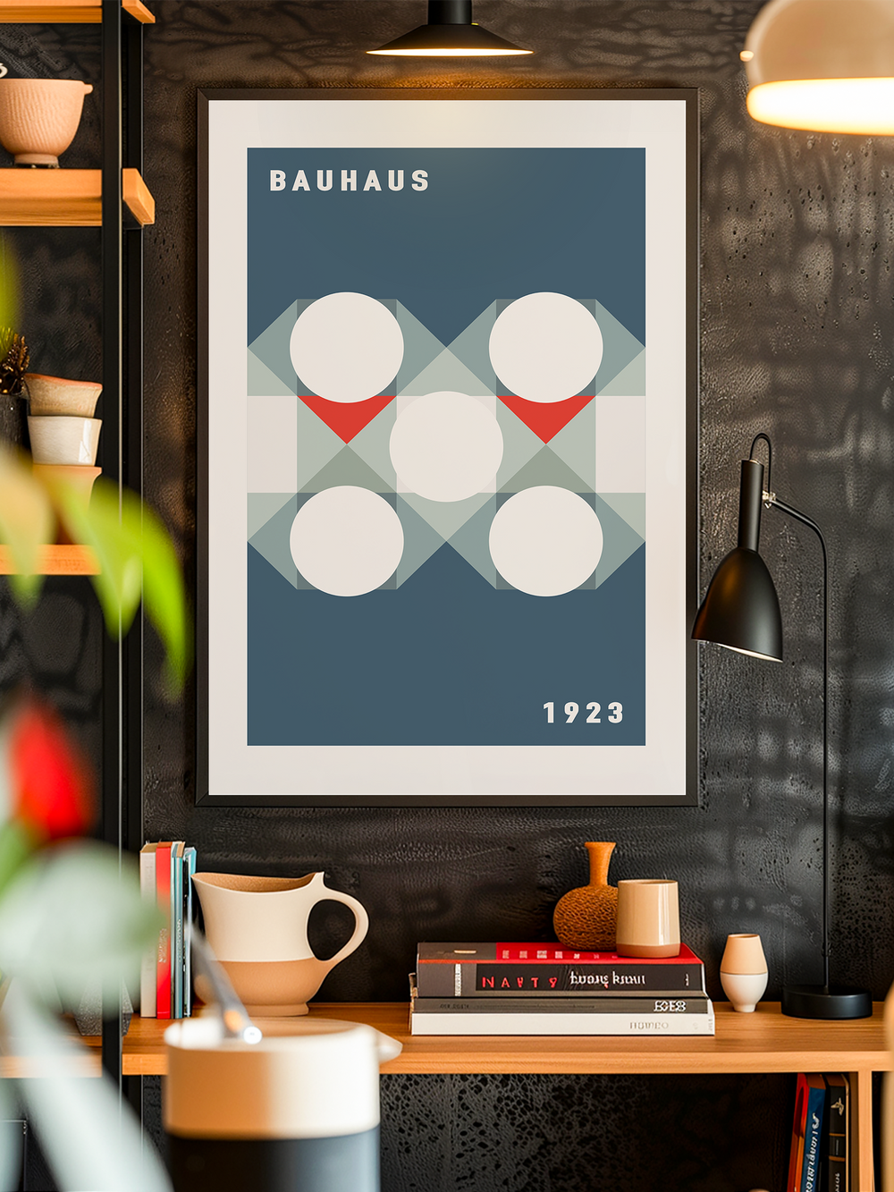 Minimalist Bauhaus-inspired poster featuring bold geometric shapes with white circles, red triangles, and overlapping blue patterns on a dark blue background. The artwork embodies modernist design principles from 1923 and is displayed in a stylish interior with shelves, books, ceramics, and soft lighting, creating a clean and artistic atmosphere.