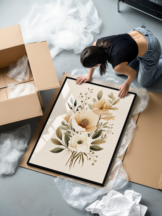 A soft neutral floral artwork featuring delicate beige and cream blossoms surrounded by muted green leaves, arranged in a refined botanical composition. The print is displayed in a sleek black aluminum frame with shatterproof plexiglass and printed on premium 200 gsm matte museum-quality paper for crisp detail, natural texture, and long-lasting color. A calming, timeless piece ideal for modern interiors, bedrooms, and living spaces seeking elegant botanical wall decor.