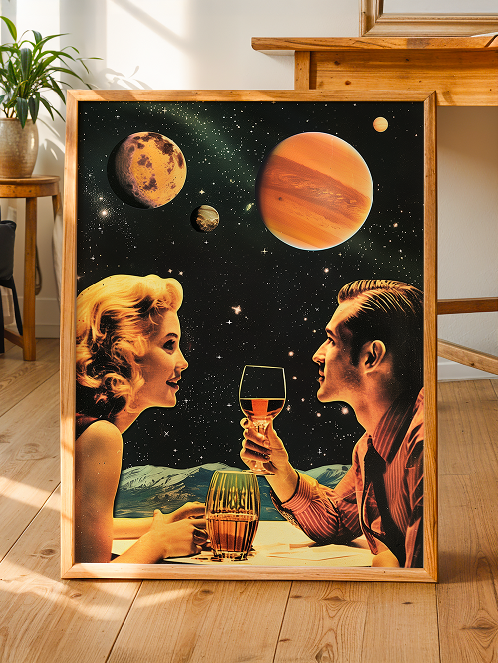 Framed vintage sci-fi poster showing a man and woman toasting under a sky filled with colorful planets and stars, styled in a mid-century retro aesthetic. The artwork leans against a wall in a bright, natural wood interior with plants and minimalist decor, creating a warm and nostalgic atmosphere perfect for unique space-themed wall art lovers.