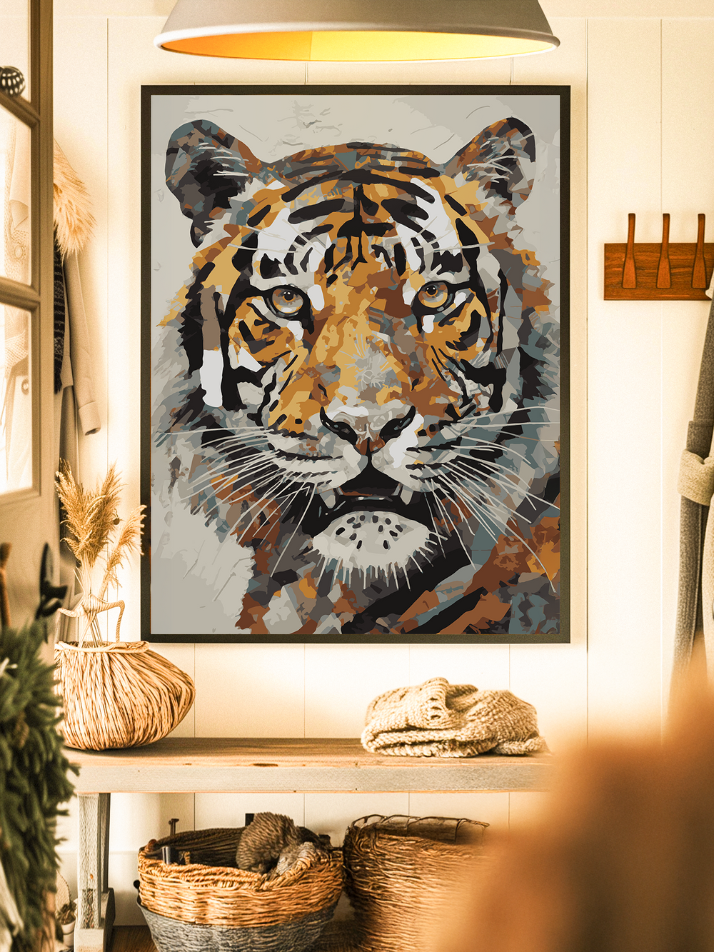 Framed tiger artwork in bold orange, black, and neutral tones displayed on a white textured wall. The print features a close-up of a tiger’s face with a modern, abstract style. It hangs above a wooden console table decorated with woven baskets and natural elements, creating a cozy, rustic atmosphere.