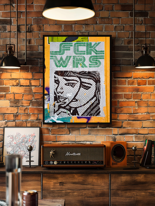 Framed pop art poster featuring bold graffiti-style lettering and a comic-style female face, hanging on an exposed brick wall in a stylish loft with industrial lighting, wooden sideboard, retro amplifier, and bookshelf.