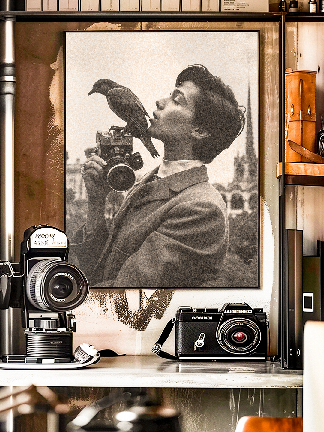Artistic black and white portrait of a young person in a suit holding a vintage camera while a bird perches on top, creating a surreal and nostalgic mood. The poster is displayed among classic film cameras and retro photography decor, emphasizing a timeless aesthetic that blends fine art and vintage photography.